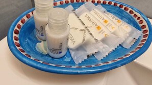 A blue ceramic dish containing three bottles of Arisia shampoo and two bars of soap. - B&B Acquamarine (Salerno)