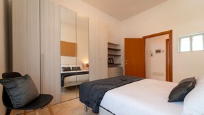 A bedroom with a bed, a chair, a wardrobe, and a desk. - Bright and Cozy in Menaggio by Wonderful Italy (Menaggio)