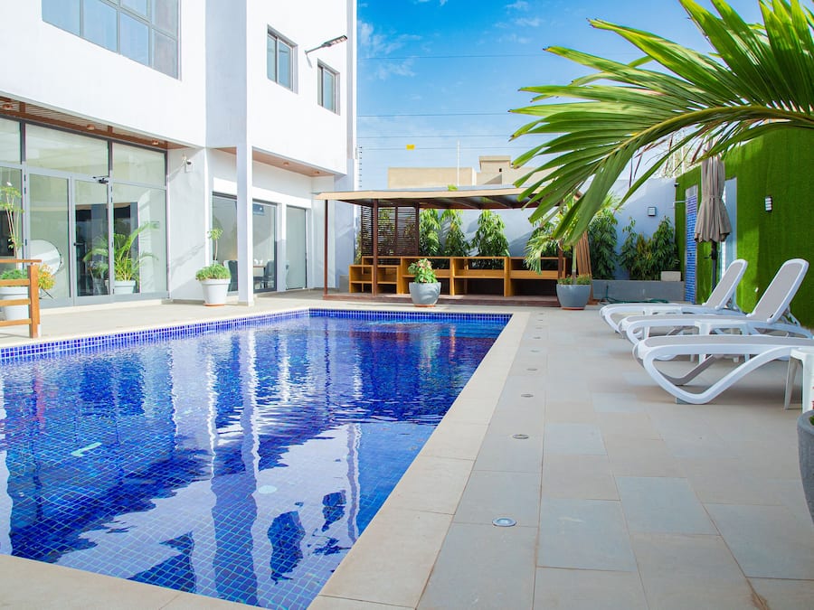 A swimming pool with lounge chairs and potted plants.