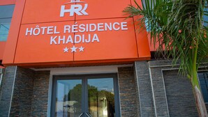 A hotel sign with the name "Hôtel Résidence Khadija" and a logo.