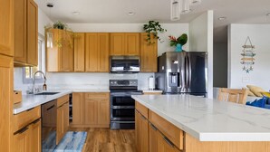 Una cocina moderna con armarios de madera, electrodomésticos de acero inoxidable y encimera de mármol.
