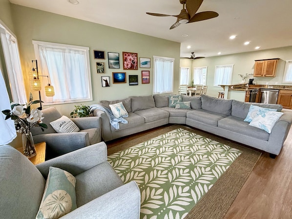 A living room with a sectional sofa, a coffee table, and a patterned rug. - "Hina Hideaway", Views, A/C, Walkable to Beach (Punaluu)