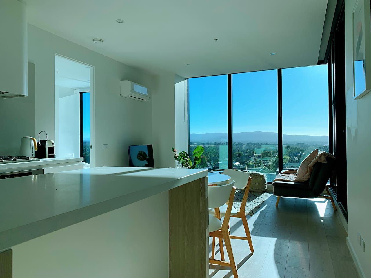 A modern kitchen with a large island, a dining area with a view, and a seating area with a view.
