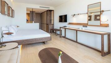 Habitación de hotel moderna con una cama grande, un escritorio, un tocador y un televisor.