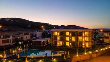 Un resort con piscina, varias edificaciones y un paisaje montañoso.