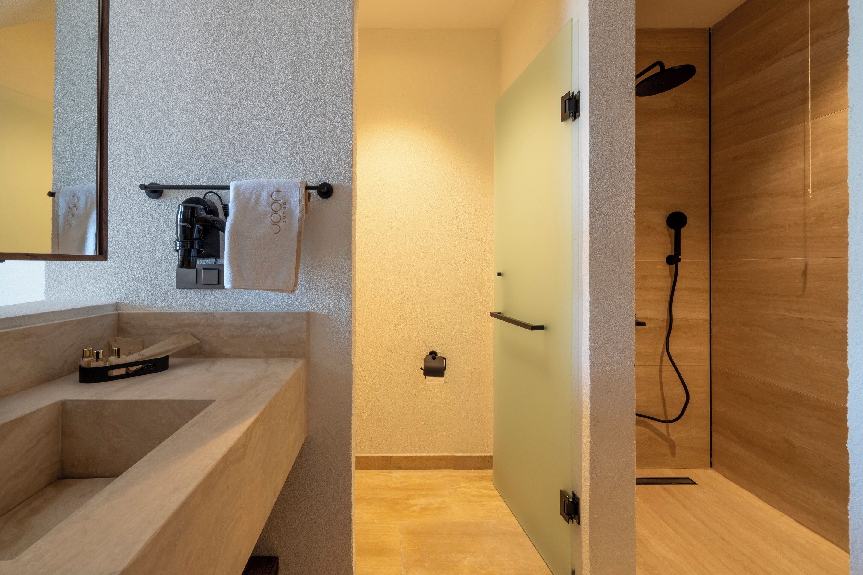 A modern bathroom with a large mirror, a sink, a towel rack, and a shower area.