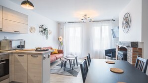 Una cucina moderna con zona pranzo, camino e soggiorno con divano e tavolino.
