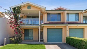 A two-story house with a garage, a balcony, and a well-maintained lawn. - Ted's at Broulee (Broulee)