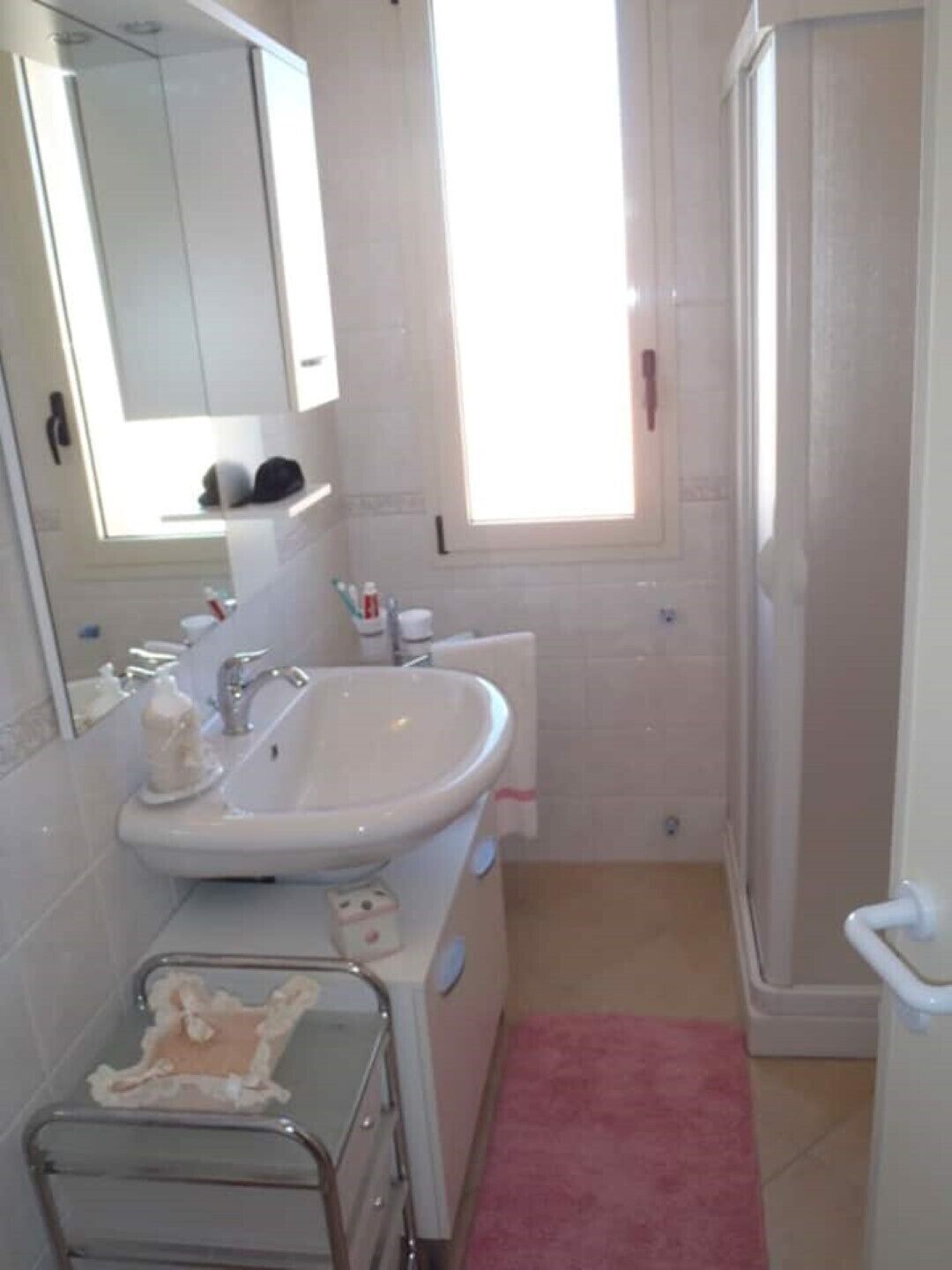 Ein Badezimmer mit Waschbecken, Spiegel und Dusche.