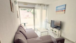 En moderne stue med en sofa, fjernsyn og ventilator.