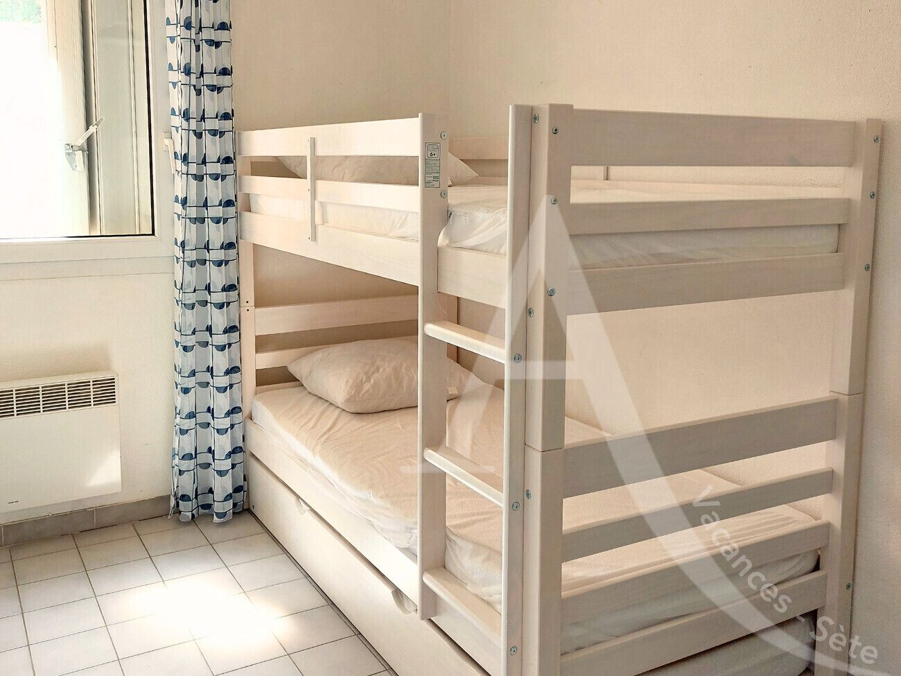 A bunk bed with a window and a radiator.