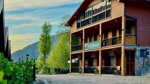 A two-story building with a sign reading 'KONAK' and outdoor seating. - Konak Grand Apart (Çaykara)