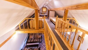 A wooden staircase leading to a loft bedroom with a bed, a desk, and a chair. - Villa Dolina Miru (Zavrc)