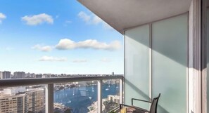 Un balcon avec vue sur un port de plaisance et sur le paysage urbain.