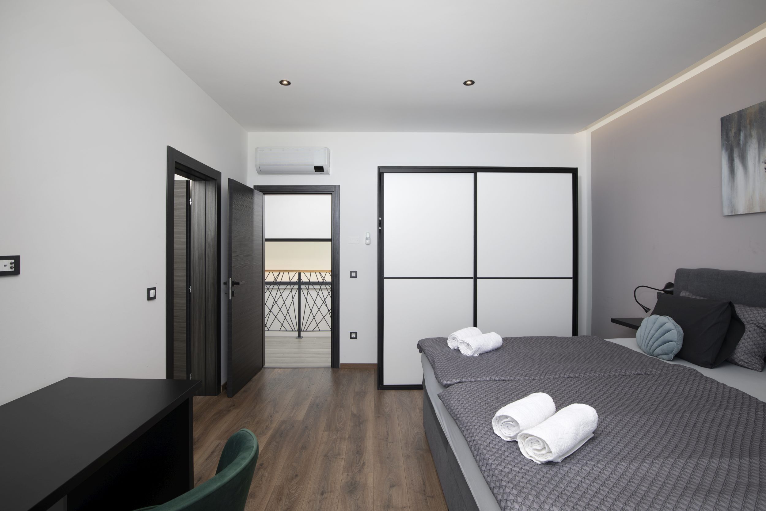 Un dormitorio moderno con una cama, un escritorio y una silla.