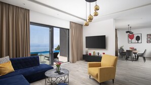A modern living room with a sofa, armchair, and dining area, large windows, and a flat-screen TV. - Villa Ziganto with a view of the Kvarner Bay (Poljane)