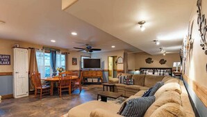 A cozy living room with a sofa, a television, and a dining area with chairs and a table. - Red Bird Cabin - Studio Retreat (Kingsland)