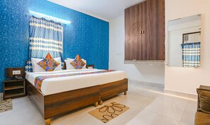 A bedroom with a bed, nightstands, a wooden wardrobe, and a window with curtains.