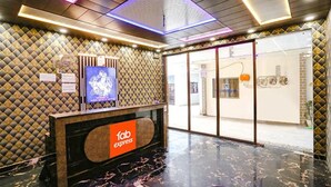 A reception area with a 'fab express' sign, a patterned wall, and a glass door leading to another room. - Fabexpress Mirage (New Delhi)