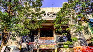 A building with multiple signs advertising various businesses, including a cyber cafe and a new SP sales and service center. - FabHotel Sai Chatra (Nashik)