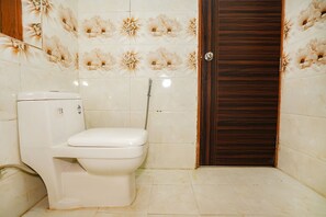 Un bany amb vàter, dutxa i porta.
