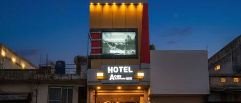 A modern building with a sign for 'fabHOTELS' and 'HOTEL A ONE INN'.