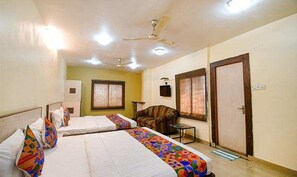 Une chambre d’hôtel avec deux lits, un ventilateur de plafond et une porte.