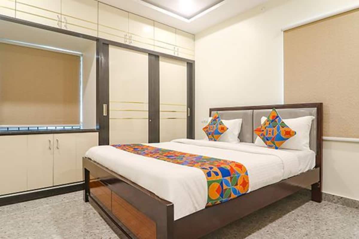 A bedroom with a bed, a wardrobe, and a window.