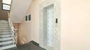 A staircase leading to a door with a frosted glass panel. - FabHotel SR Hitech City (Hyderabad)