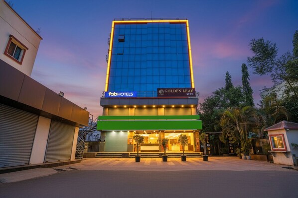A tall hotel building with a green entrance and a sign for 'fabHOTELS'.