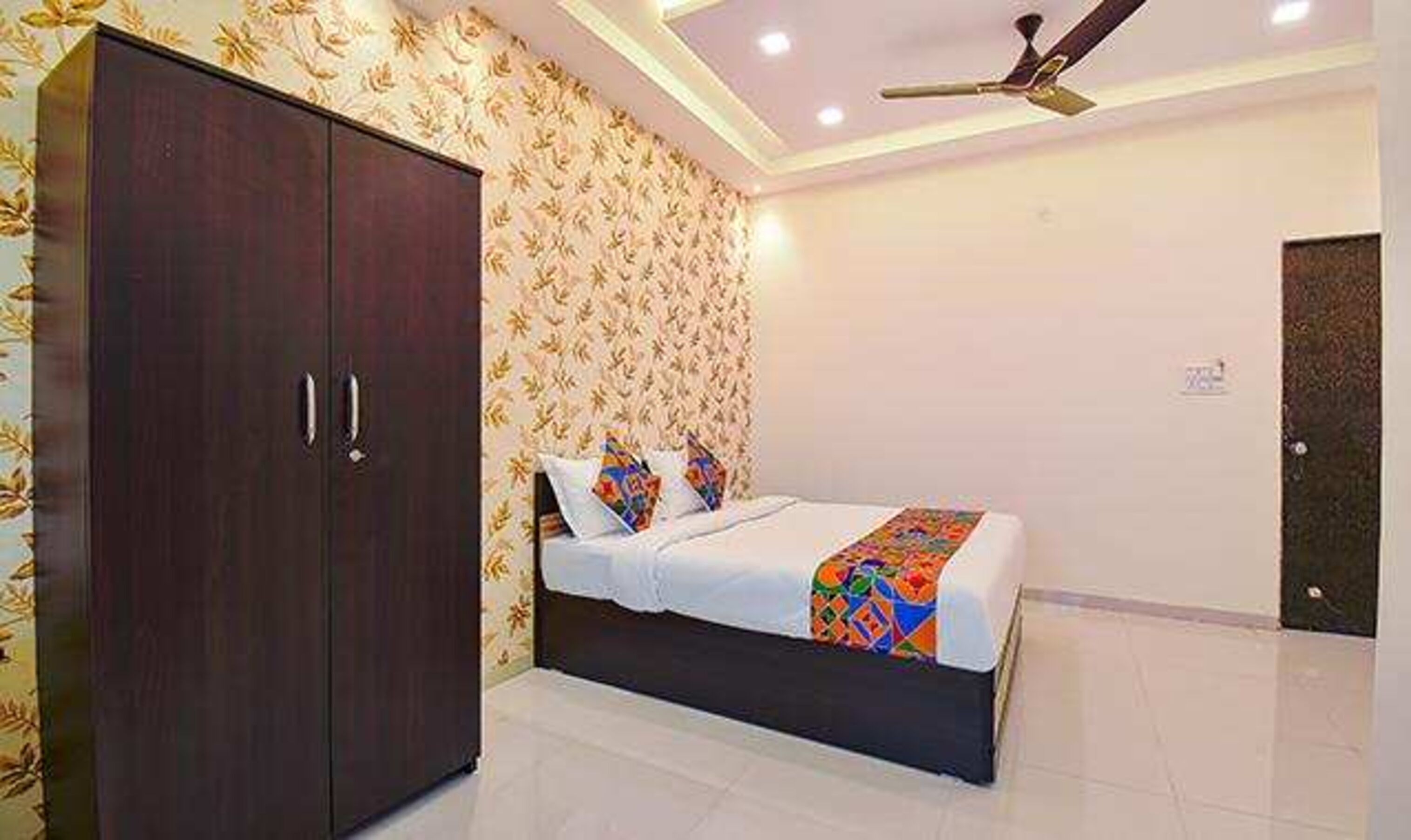 A bedroom with a bed, a wardrobe, and a ceiling fan.