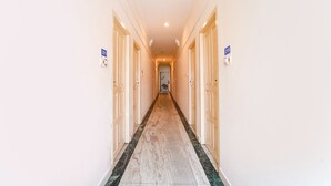 Un pasillo de hotel con puertas a ambos lados, numeradas 201 y 202, y un suelo de mármol.