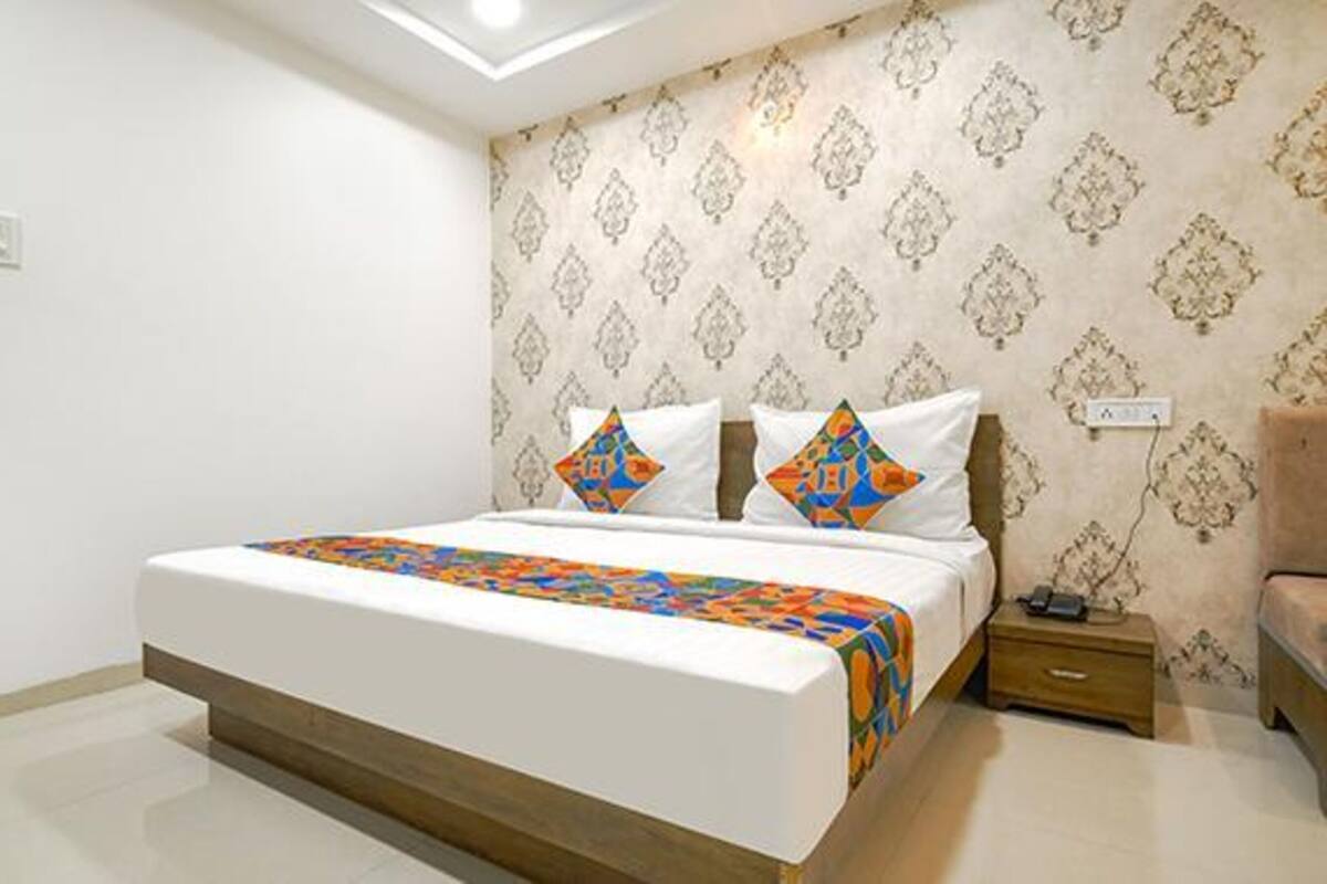 A bedroom with a bed, a nightstand, and a wooden bench.