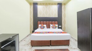 Un dormitorio con cama, ventilador de techo, mesita de noche y armario.