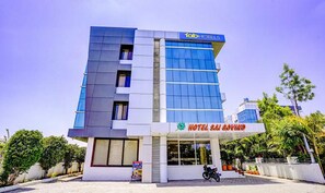 A modern hotel building with a prominent 'FabHotels' sign, a large glass facade, and a visible entrance with a motorcycle parked outside. - Fabhotel Sai Govind (Rahata)