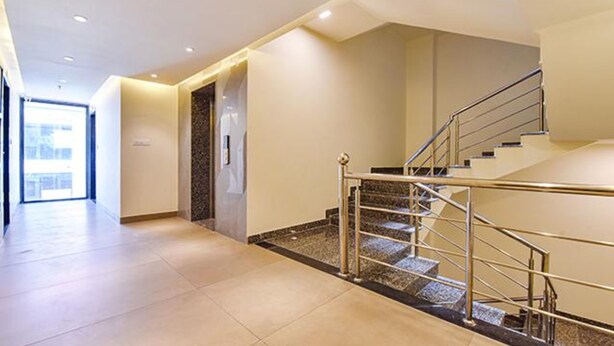 A modern hotel corridor with a staircase leading to an upper floor. - Fabhotel Prime Pink City Park (Jaipur)