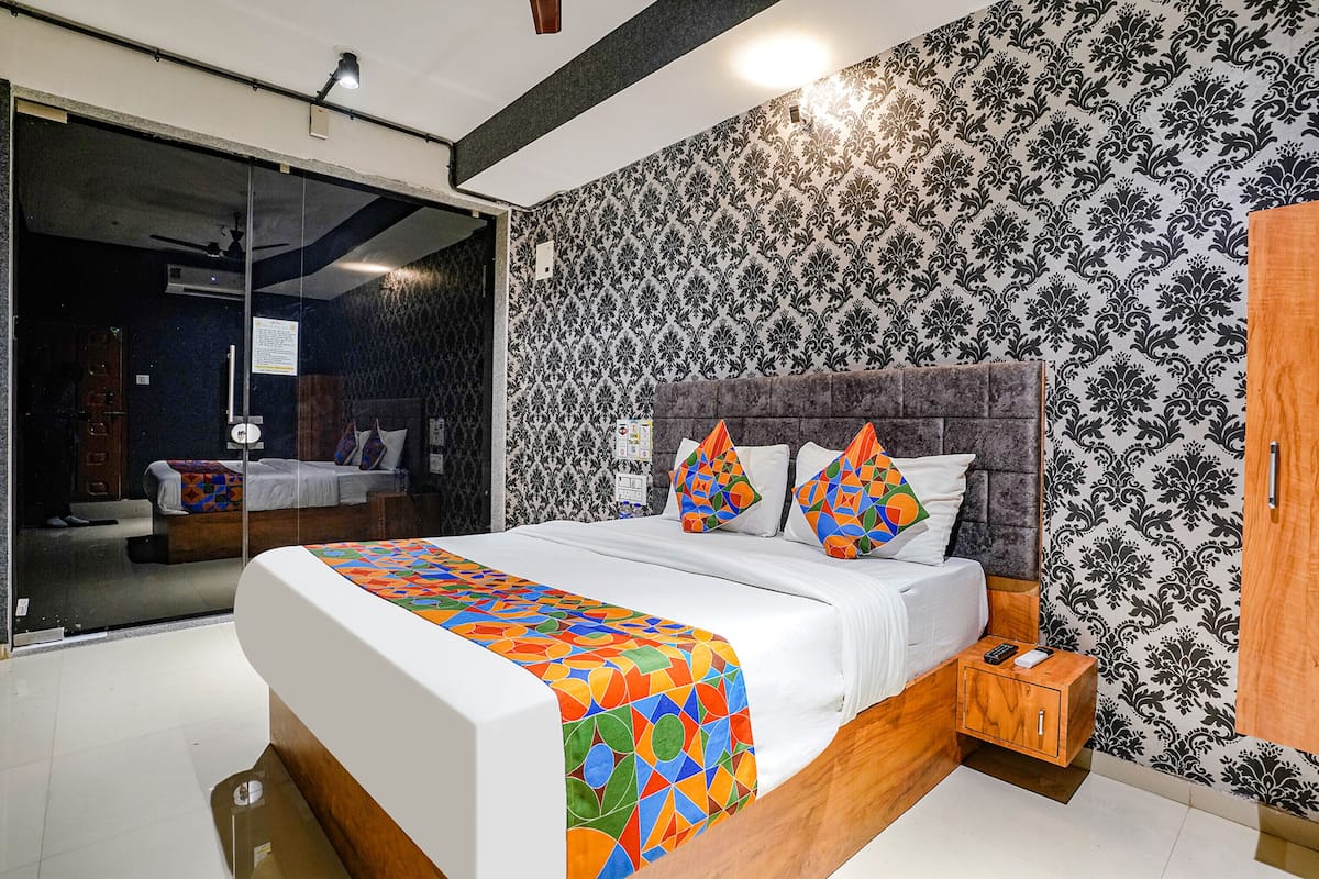 A modern bedroom with a large bed, a nightstand, and a wardrobe.