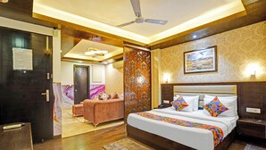 Une chambre d’hôtel comprenant un lit, un bureau, une chaise, un canapé et un panneau décoratif mural.