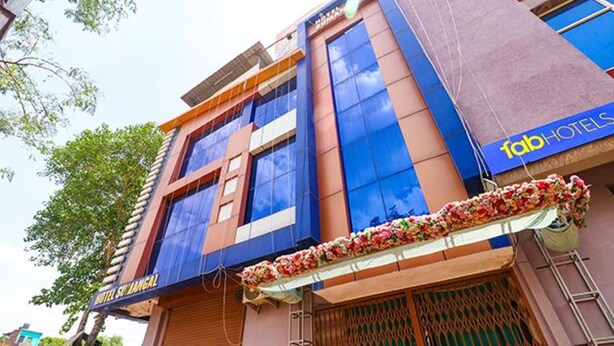 Un hotel con una fachada moderna, que presenta un letrero llamativo que dice 'HOTEL SINGHAL' y otro para 'fabHOTELS'.