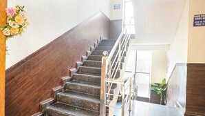 Una escalera con barandillas de madera y un letrero que indica zona sin niños.