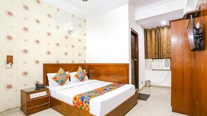 A bedroom with a wooden bed, a nightstand, a wardrobe, and a patterned wall. - Fabexpress Station Ii (New Delhi)
