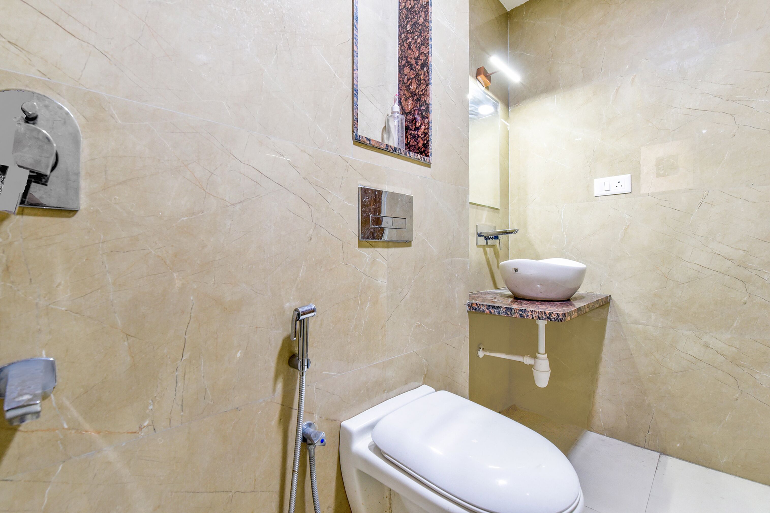 A bathroom with a toilet, a sink, a shower, and a mirror.