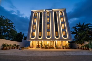 Een modern hotel met een opvallend 'fabHOTELS' bord, met een symmetrische gevel, grote ramen en een centrale ingang.