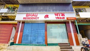 A building with a sign reading "BHAU RESIDENCY" and "fabexpress" indicating a hotel and a fast food outlet. - Fabexpress Bhau Residency (Mumbai)