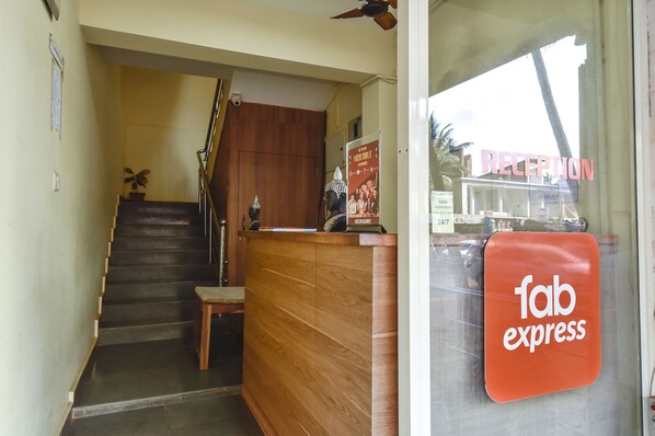 A reception area with a wooden desk, a staircase, and a sign for 'fab express'.