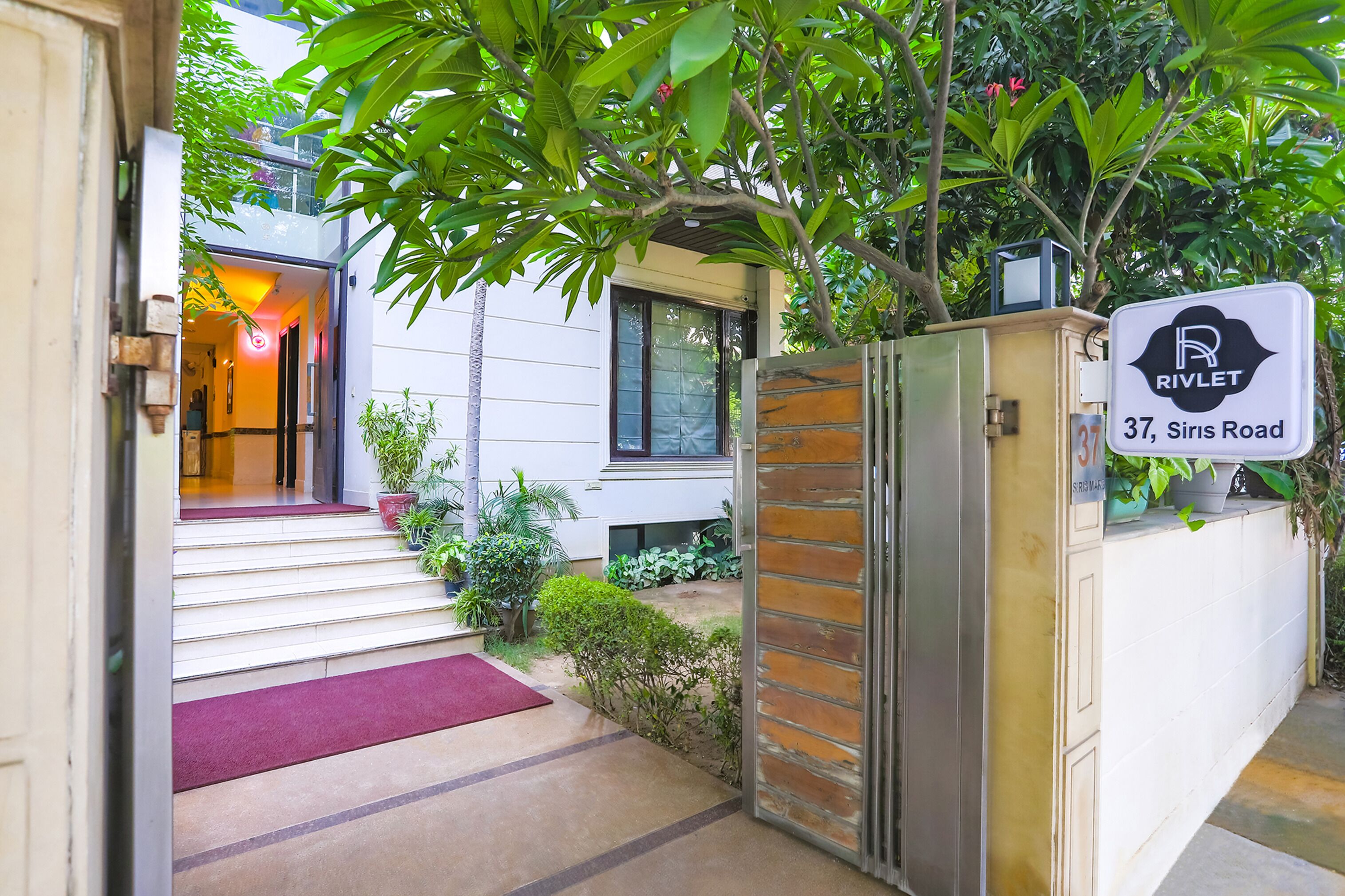 A gated entrance to a property with a sign indicating "RIVLET 37, Siris Road."