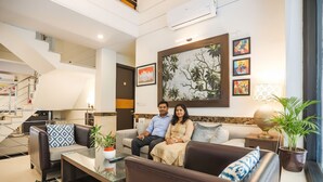 A modern living room with a sofa set, a coffee table, and a potted plant. - FabHotel Rivlet Residency (Gurugram)