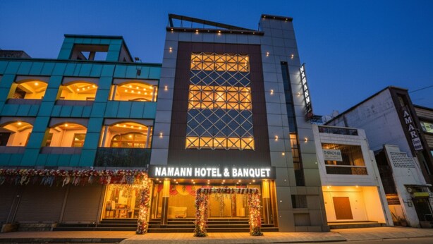 A hotel with a modern facade, a prominent entrance with a balcony, and a sign reading "NAMANN HOTEL & BANQUET". - Fabhotel Naman (Kanpur)