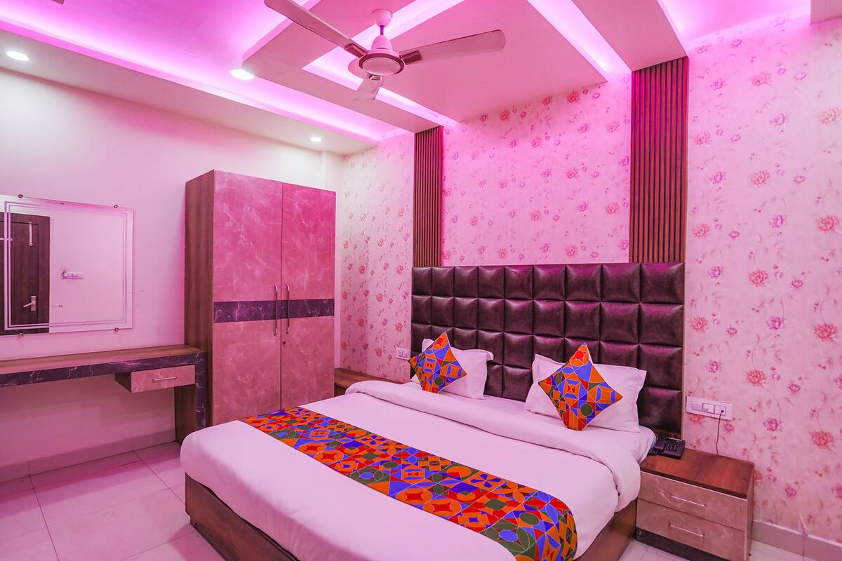 A bedroom with a bed, a wardrobe, a desk, and a ceiling fan.