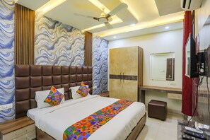 Una habitación de hotel moderna con una cama grande, un armario, un televisor y un ventilador de techo.